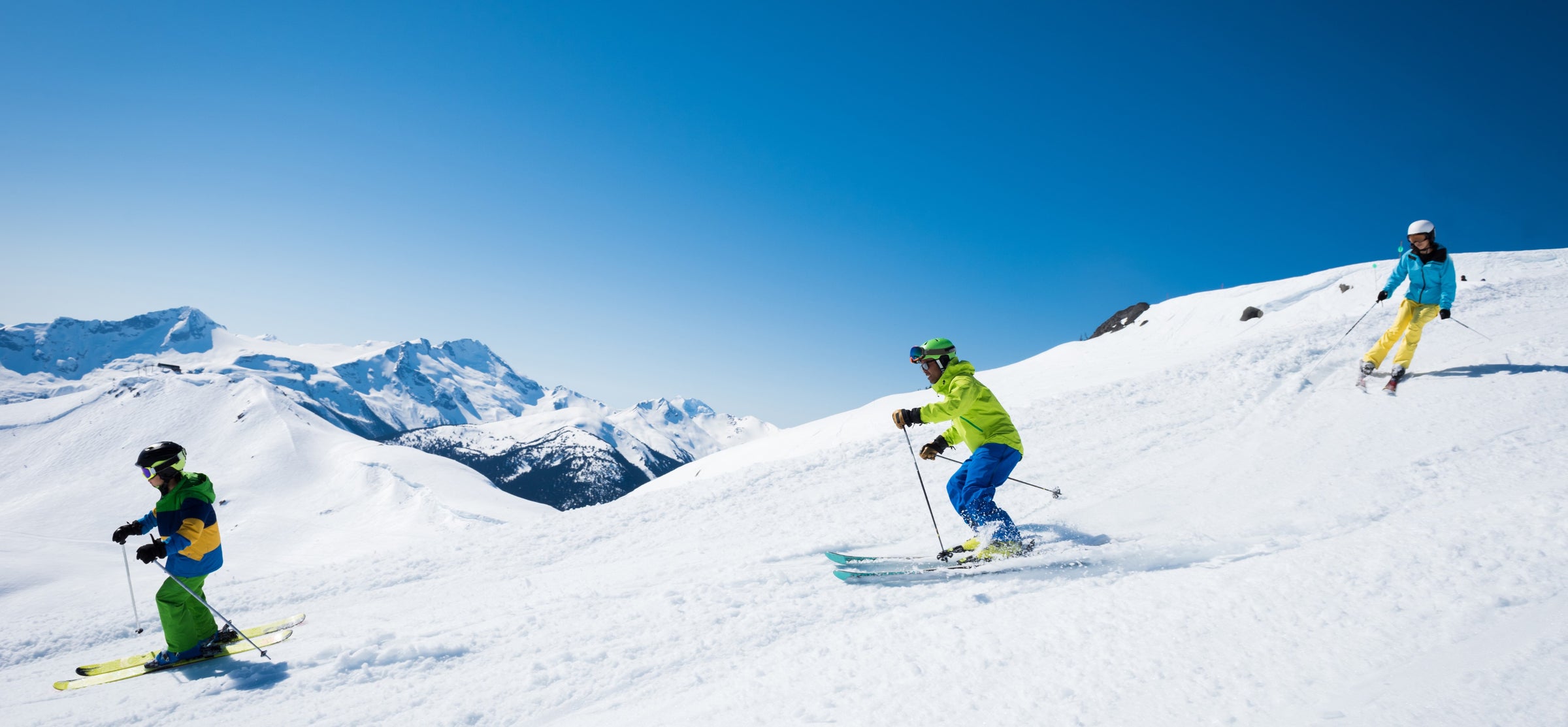 Happy family skiing together down the slope
