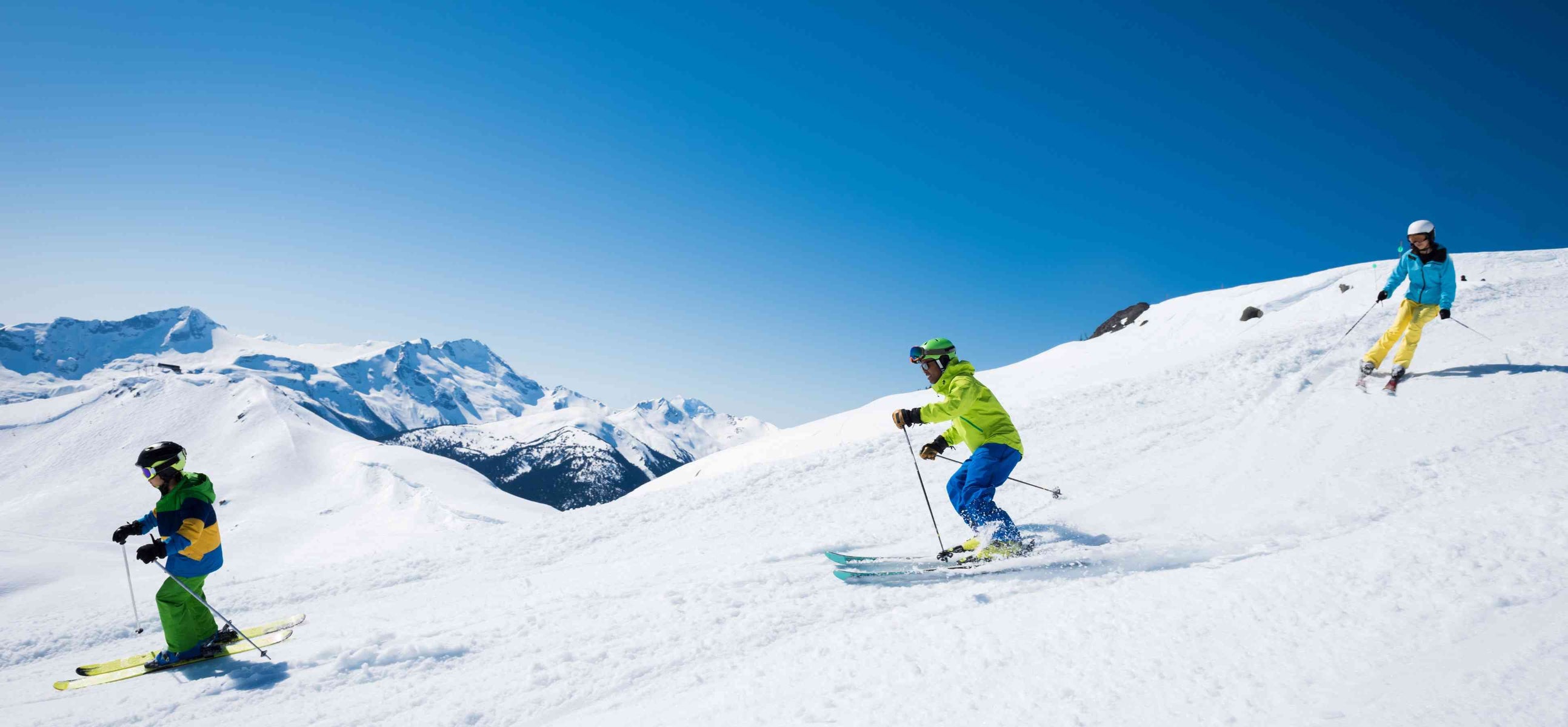 Happy Family Skiing Down The Slope